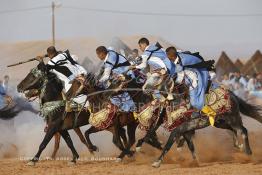 Image du Maroc Professionnelle de  Course typiquement marocaine dite ''la Fantasia'' organisé dans un site désertique sur lequel la ville de Tan Tan a toujours accueilli la majorité des tribus et des grandes familles nomades du désert lors d'un grand Moussem, Samedi 7 Septembre 2013. Le festival parrainé par l'UNESCO rassemble des milliers de nomades du Maroc. (Photo / Abdeljalil Bounhar) 